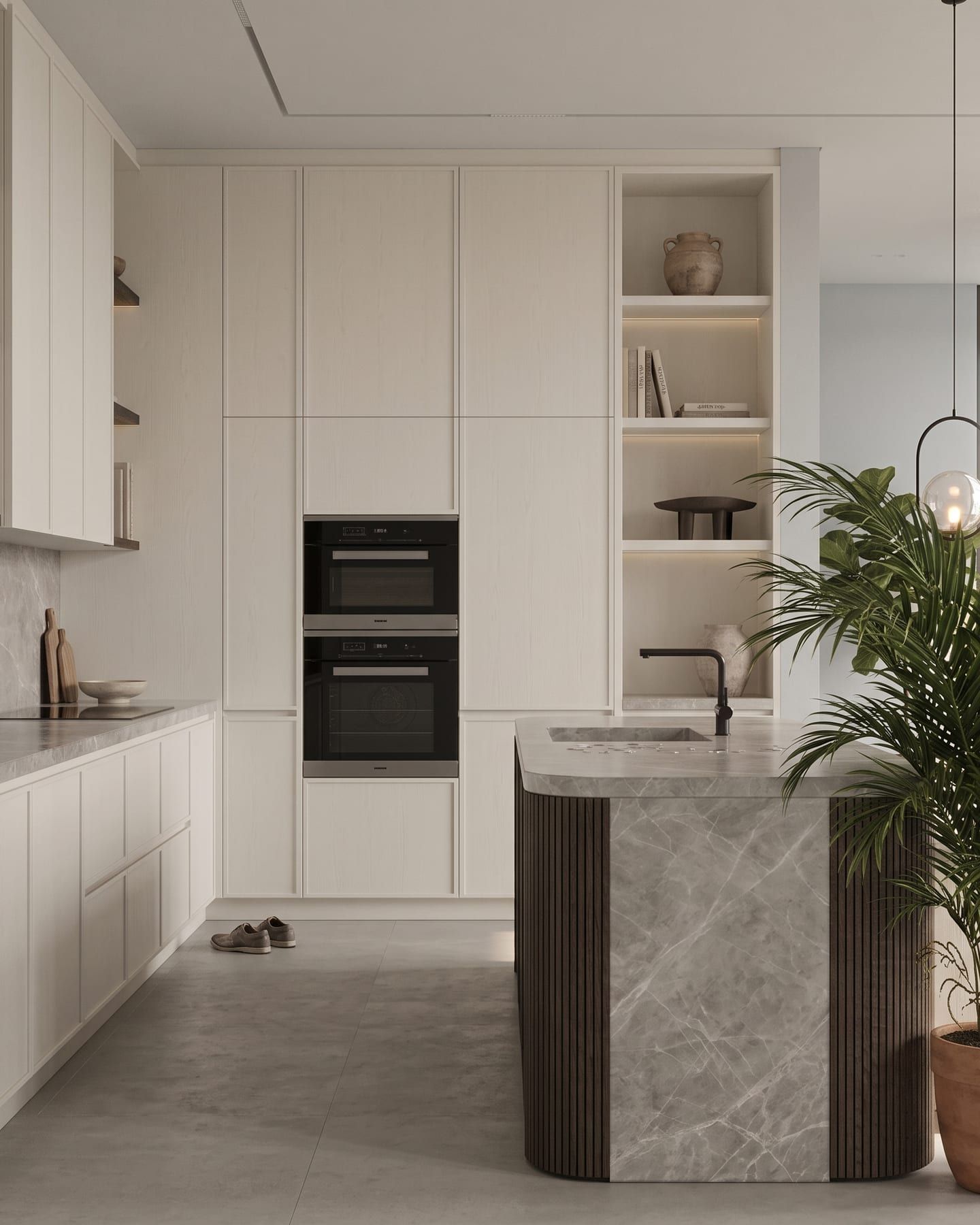 Kitchen island fronted in fluted glass set into slim brass frames, with built-in ovens and a timber splashback behind
