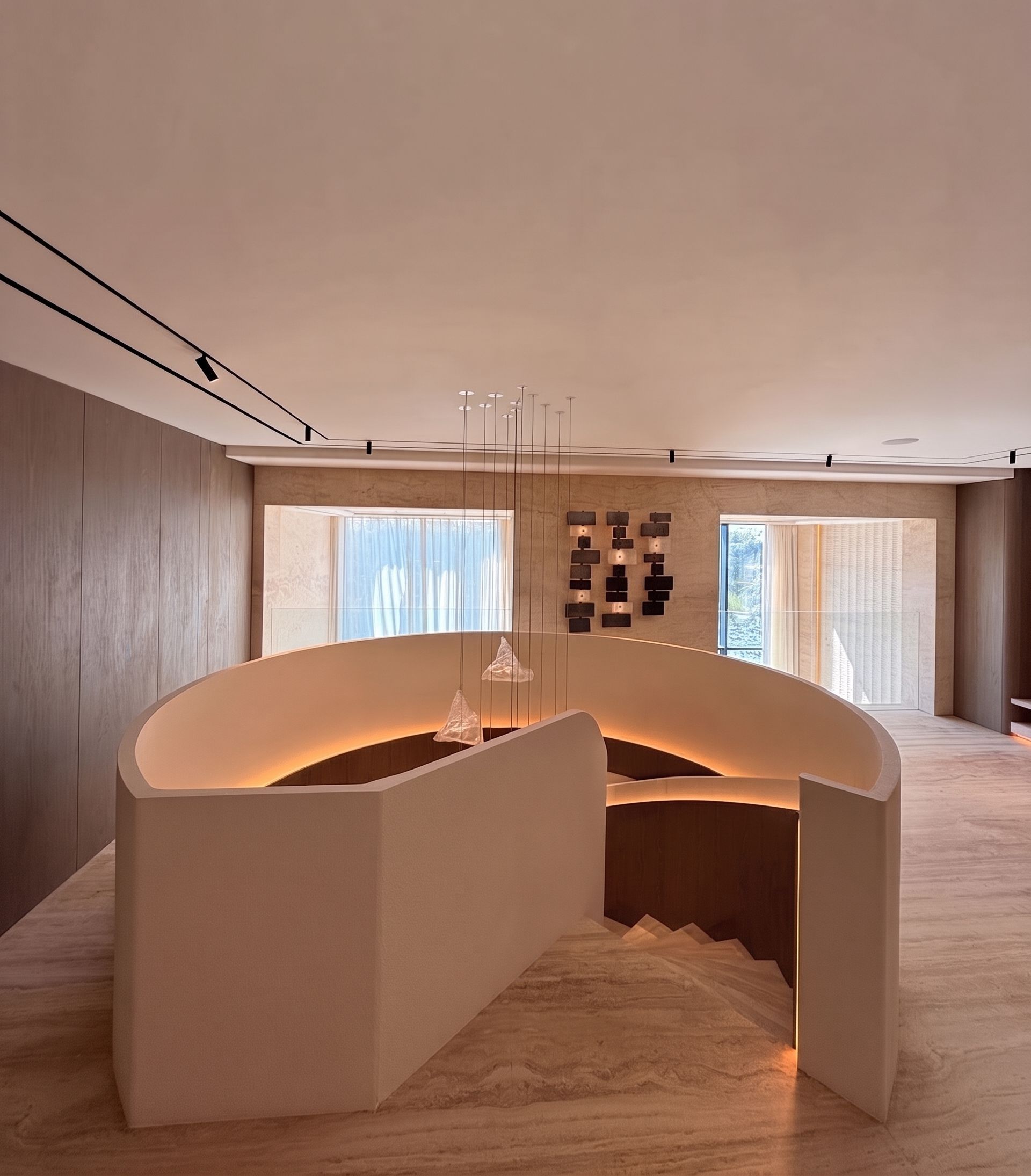 The stair reads as a sculpted plaster drum in the room — finished flush, lit from within and set against timber-panelled walls.