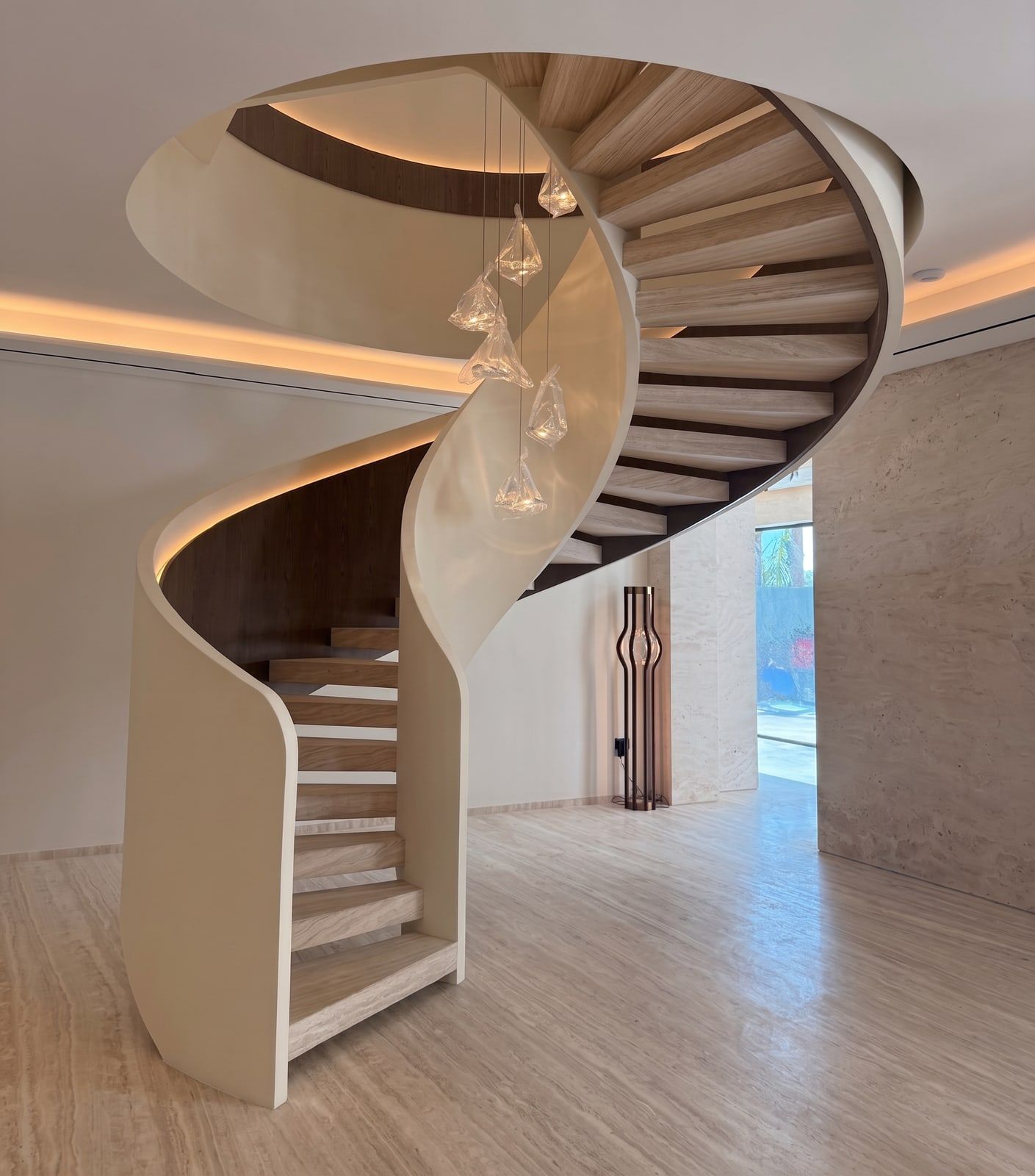 A solid plaster spiral wrapping timber treads, cove lighting hidden under the curve and glass pendants dropped through the void.