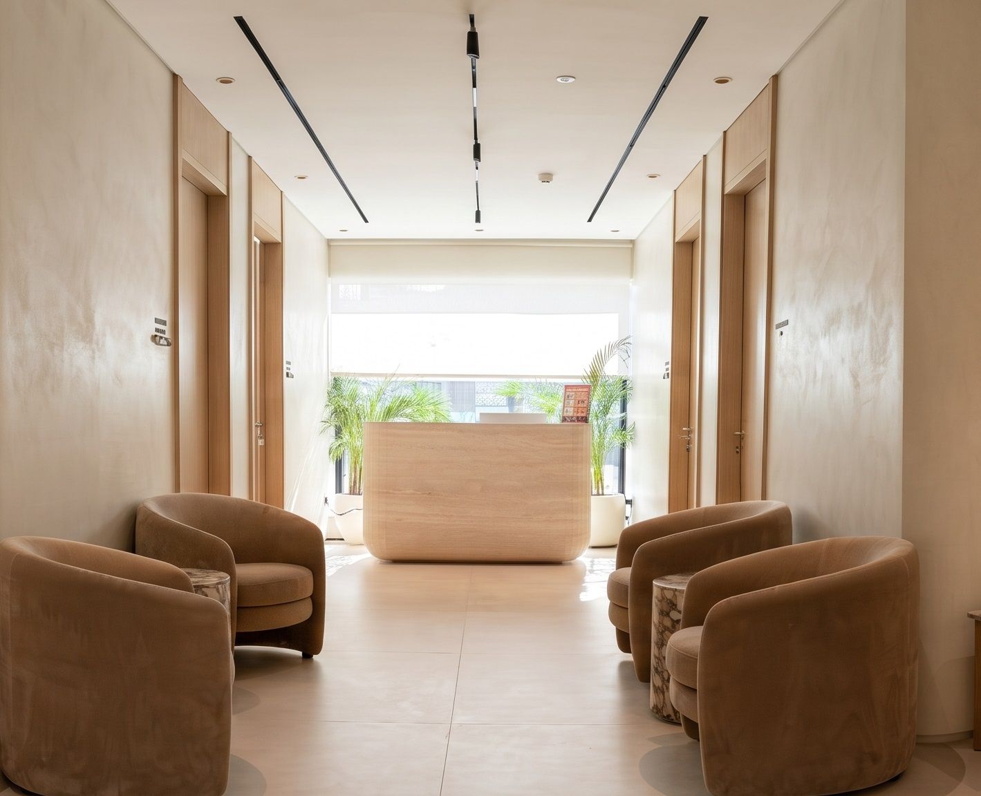 Oak-framed doorsets and recessed track lighting along a plastered corridor with waiting seating.